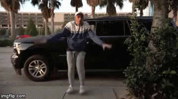 a man is dancing in front of a suv .
