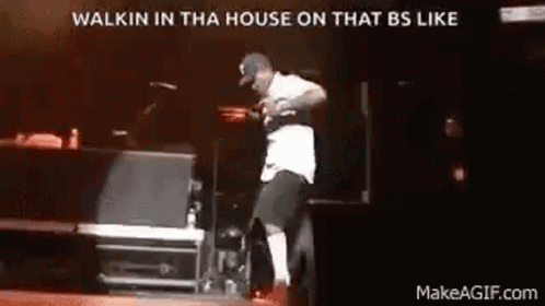 A Man Is Dancing On A Stage In Front Of A Microphone . GIF