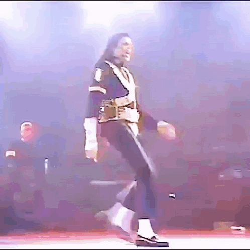 A Man Is Dancing On A Stage With A Purple Background . GIF