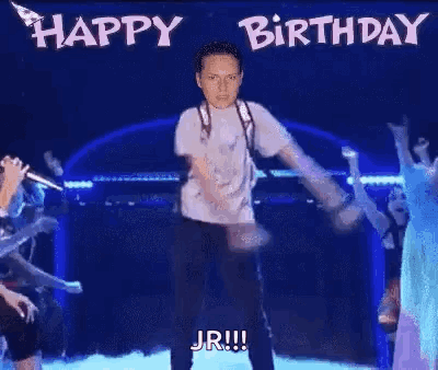 A Man Is Dancing On A Stage With The Words `` Happy Birthday Jr '' Written On The Background . GIF