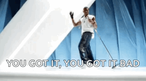 A Man Is Dancing On A Stage With The Words `` You Got It , You Got It Bad '' Behind Him . GIF