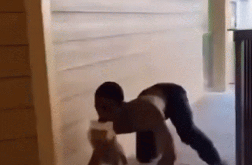 A Man Is Doing A Handstand In A Doorway While Holding A Bottle Of Water . GIF