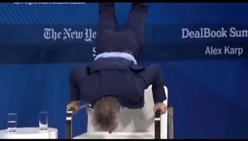 A Man Is Doing A Handstand In Front Of A Sign For The New York Times GIF