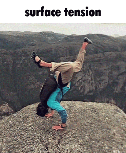 A Man Is Doing A Handstand On Top Of A Rock With The Words Surface Tension Behind Him GIF