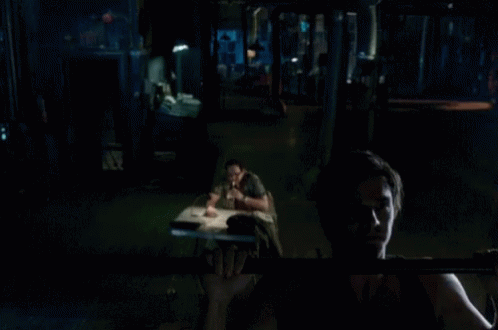 A Man Is Doing A Pull Up In The Dark GIF