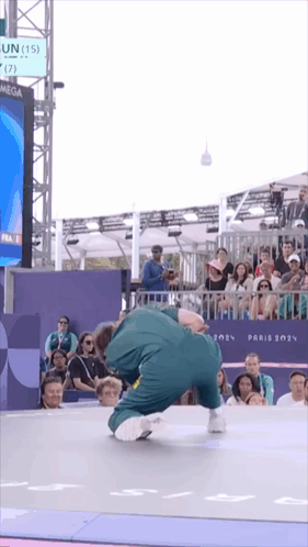 A Man Is Doing A Trick In Front Of A Crowd And A Sign That Says Omega GIF