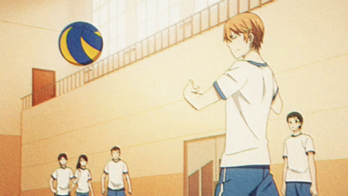 A Man Is Doing A Trick With A Volleyball In A Gym GIF