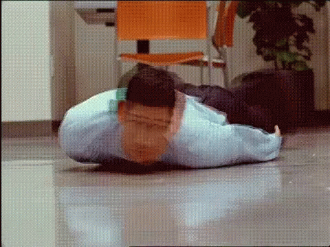 A Man Is Doing Push Ups On The Floor In A Room . GIF