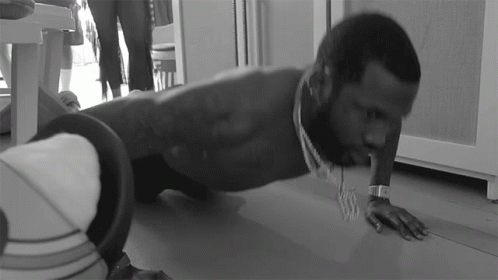A Man Is Doing Push Ups On The Floor While Wearing A Watch GIF