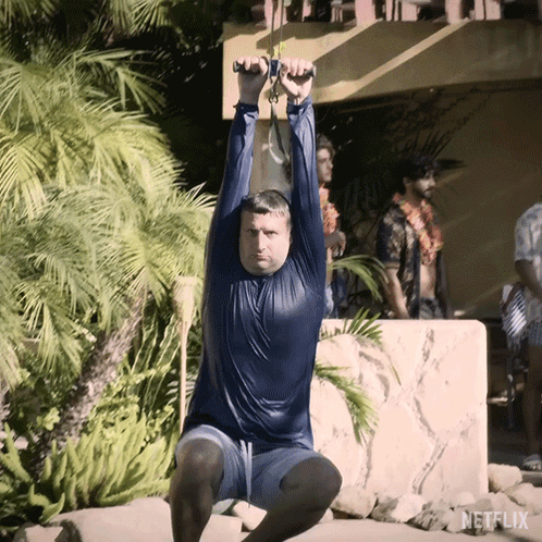A Man Is Doing Squats In Front Of A Netflix Logo GIF