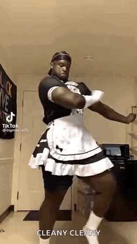 A Man Is Dressed As A Maid And Dancing In A Kitchen . GIF