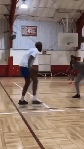 A Man Is Dribbling A Basketball On A Court GIF
