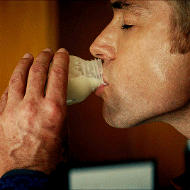 A Man Is Drinking From A Bottle With His Hand GIF