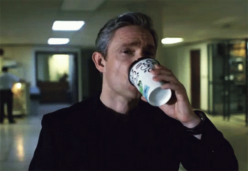 A Man Is Drinking From A Cup That Says Coffee GIF