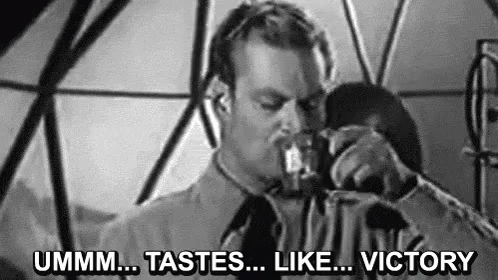 A Man Is Drinking From A Glass In A Black And White Photo And Saying `` Ummm ... Tastes ... Like ... Victory '' . GIF