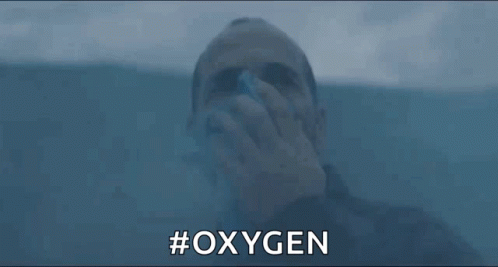 A Man Is Drinking Oxygen From A Bottle While Swimming In The Water . GIF