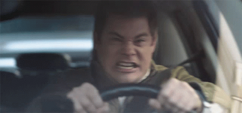 A Man Is Driving A Car And Making A Very Angry Face GIF