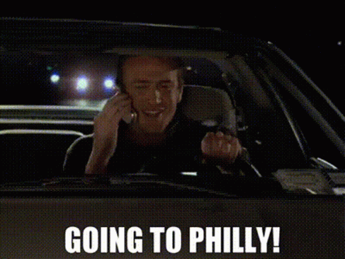 A Man Is Driving A Car And Talking On A Cell Phone With The Words Going To Philly Above Him GIF