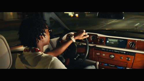 A Man Is Driving A Car With A Radio That Says ' Spotify ' On It GIF