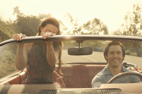 A Man Is Driving A Car With A Woman Sitting In The Back GIF