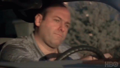 A Man Is Driving A Car With Hbo Written On The Bottom Of The Screen . GIF