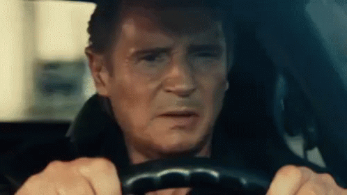 A Man Is Driving A Car With His Eyes Closed And Making A Funny Face . GIF