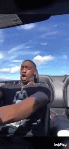 A Man Is Driving A Car With His Mouth Open .. GIF