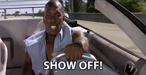 A Man Is Driving A Car With The Words Show Off On The Steering Wheel GIF