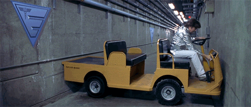 A Man Is Driving A Yellow Vehicle That Says Taylor Built GIF
