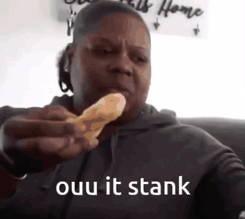 A Man Is Eating A Piece Of Pizza With The Words " Ouu It Stank " Written Below Him GIF