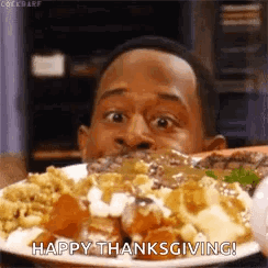 A Man Is Eating A Plate Of Food With The Words `` Happy Thanksgiving '' Written On It . GIF