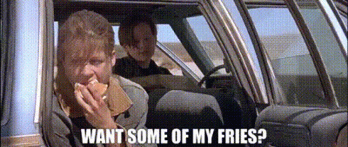 A Man Is Eating A Sandwich In A Car While Another Man Is Driving . GIF