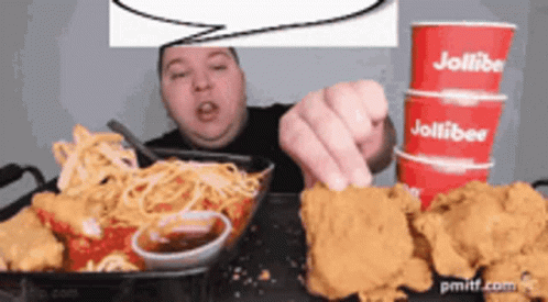 A Man Is Eating Chicken And Spaghetti With A Speech Bubble Above Him That Says Jollibee GIF