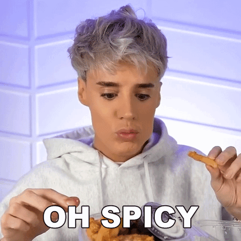 A Man Is Eating French Fries With The Words Oh Spicy Written Below Him GIF
