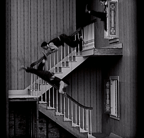A Man Is Falling Down A Set Of Stairs In A Black And White Photo GIF