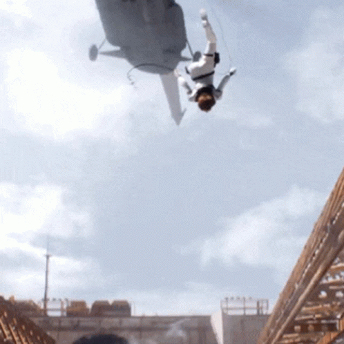 A Man Is Falling From A Helicopter In The Air GIF