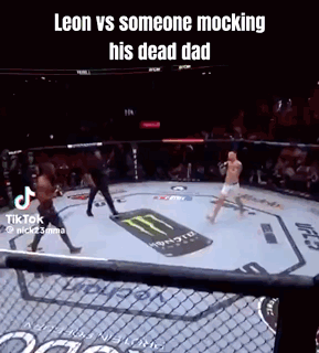 A Man Is Fighting Another Man In A Boxing Ring With A Monster Energy Logo On The Ground . GIF