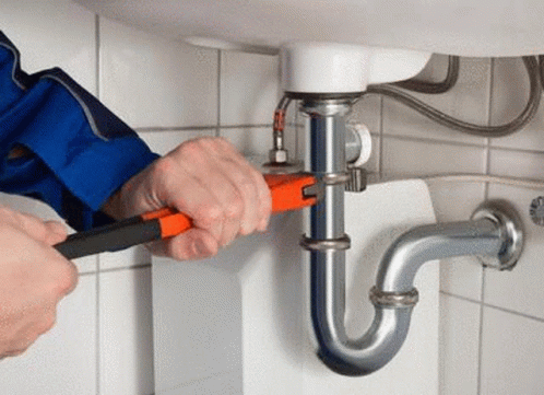A Man Is Fixing A Sink Pipe With A Wrench . GIF