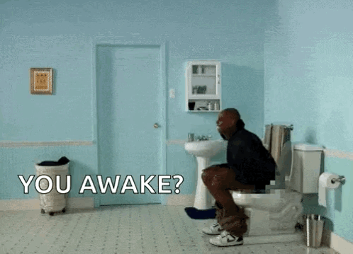 A Man Is Flying Through The Air In A Bathroom With The Words " You Awake " On The Floor GIF