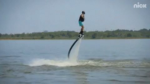 A Man Is Flying Through The Air On A Water Jet Board With The Nick Logo Behind Him GIF