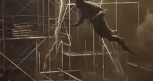A Man Is Flying Through The Air While Holding A Light . GIF