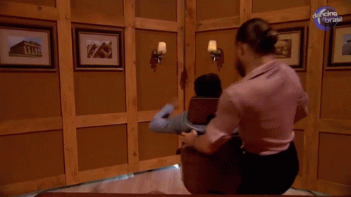 A Man Is Getting A Massage In A Room With Dancing With The Brass Written On The Bottom GIF