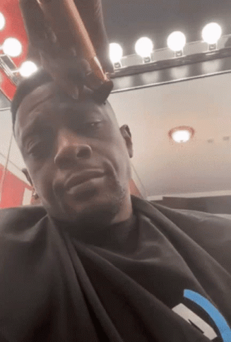 A Man Is Getting His Hair Cut By A Barber GIF