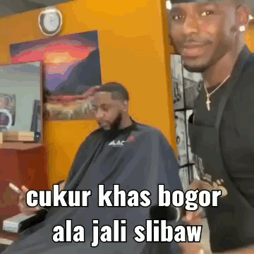 A Man Is Getting His Hair Cut By A Barber In A Barbershop . GIF