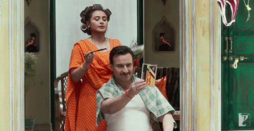 A Man Is Getting His Hair Cut By A Woman With Curlers In His Hair GIF