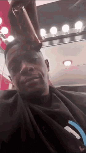 A Man Is Getting His Hair Cut In A Salon . GIF