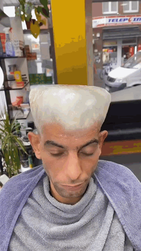 A Man Is Getting His Hair Dyed In A Barber Shop With A Sign In The Background That Says Teleport GIF