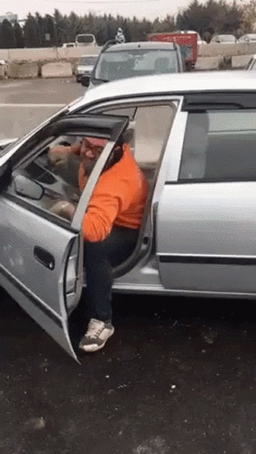 A Man Is Getting Out Of A Car With The Door Open GIF