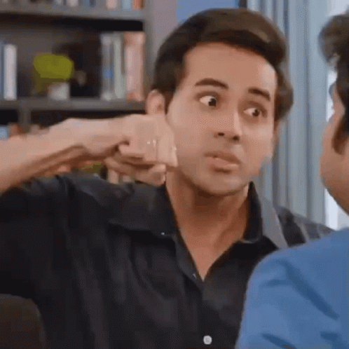 a man is giving a fist bump to another man in a living room .