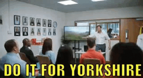 A Man Is Giving A Presentation In Front Of A Group Of People In A Room . GIF